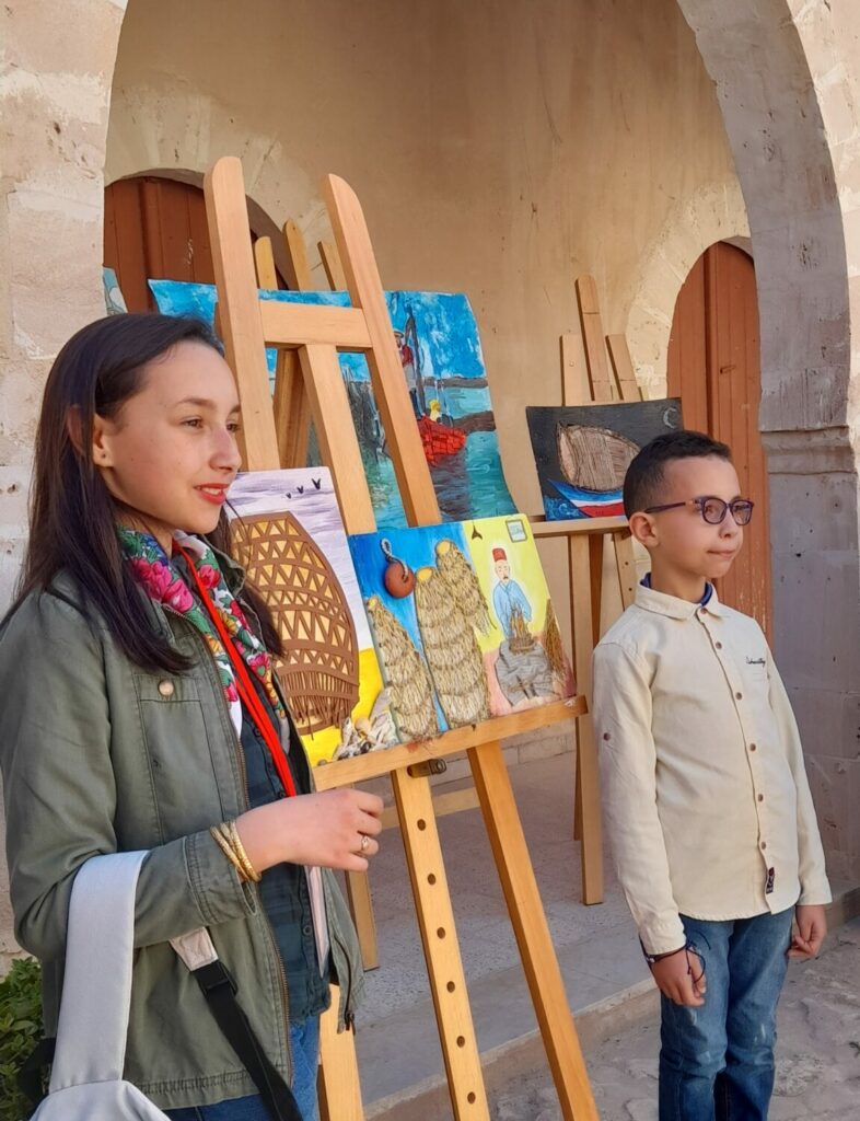 élèves fiers de leurs réalisations en peinture