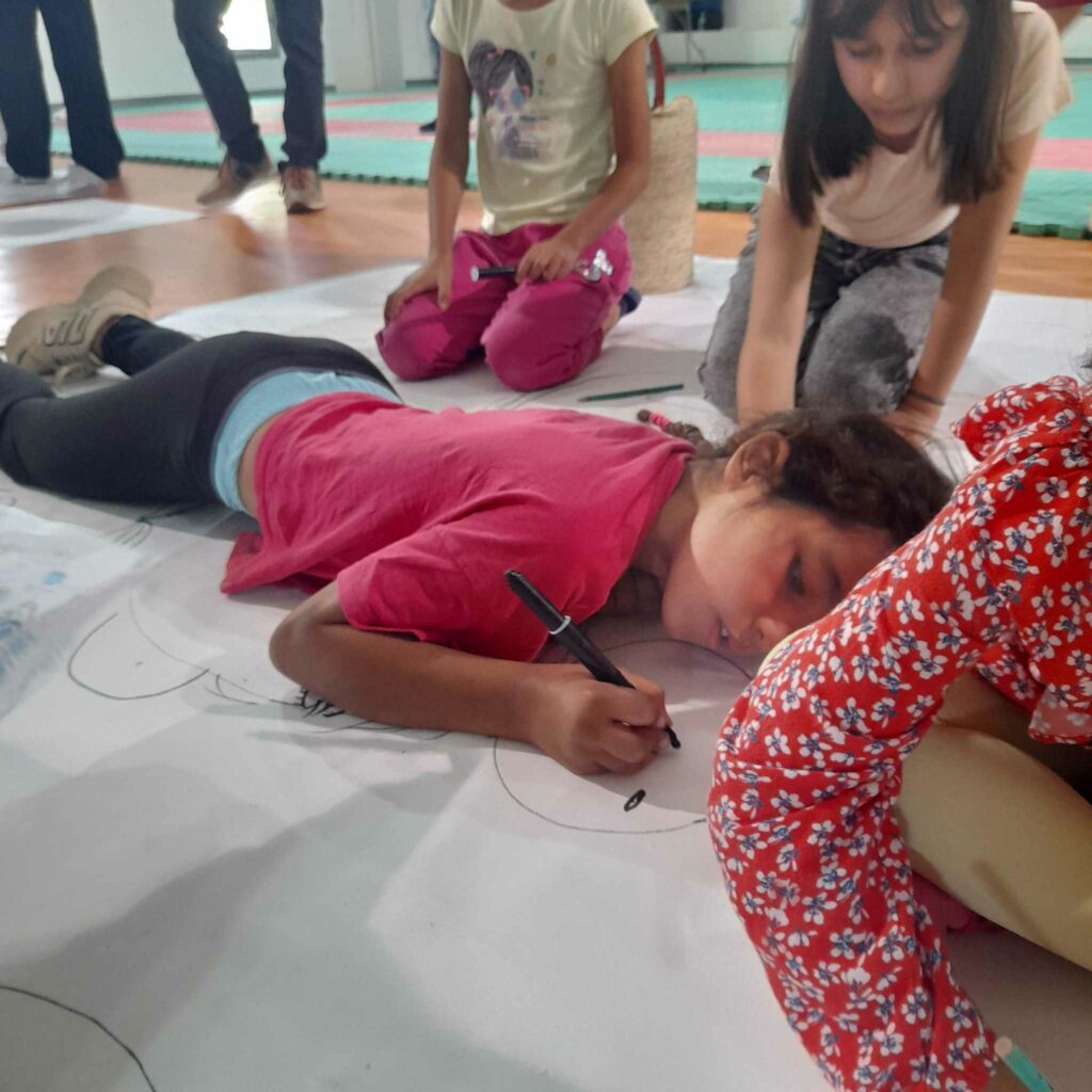 enfant en train de dessiner a plat ventre